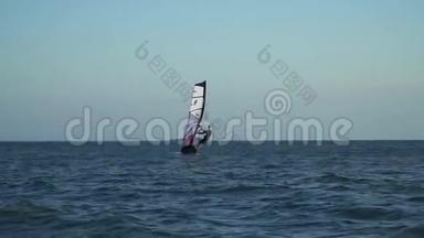 熟练的水上运动员在海角里骑着风车。 喜欢水上运动的人。 在阳光下骑着风翼